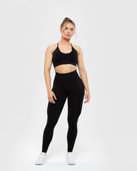 امرأة ترتدي حمالة صدر نسائية من BEST Define Seamless Racer Back باللون الأسود وبنطلون ضيق، مصنوعة من مواد عالية الجودة.