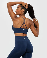 يُظهر المنظر الخلفي للمرأة دعمها المثالي من خلال حمالة الصدر BEST Define Seamless Racer Back للسيدات باللون الأزرق الياقوتي والسراويل الضيقة.