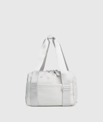 حقيبة يد صغيرة بيضاء على خلفية رمادية SAUDI SHARK Everyday Mini Holdall.