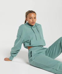 امرأة مستلقية على الأرض في Gymshark | سترة بغطاء للرأس ثقيل الوزن من United We Sweat، سترة بغطاء للرأس ثقيلة الوزن.