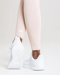 أرجل امرأة ترتدي طماق نسائية بدون خياطة من BEST Power | طماق عارية وحذاء رياضي أبيض.