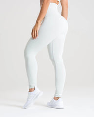 المنظر الخلفي لامرأة ترتدي بنطال ضيق ضيق باللون الرمادي الفاتح المغسول.