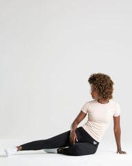 امرأة ترتدي تي شيرت بدون خياطة من أفضل ما يكون للنساء | طماق عارية وسوداء ملقاة على الأرض.