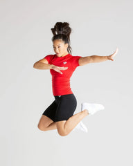 امرأة ترتدي تي شيرت بدون خياطة من أفضل ما يكون للنساء | الأحمر يقفز في الهواء ويرتدي قماشًا عالي الجودة.