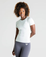 امرأة ترتدي بنطالًا رماديًا وتيشيرت نسائي بدون خياطة من Best Power باللون الرمادي الفاتح.