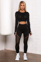 امرأة ترتدي ملابس رياضية سوداء من Fashion Nova ترتدي سروال Block Me Active Infinity Seamless - أسود، تقف أمام كيس ملاكمة.