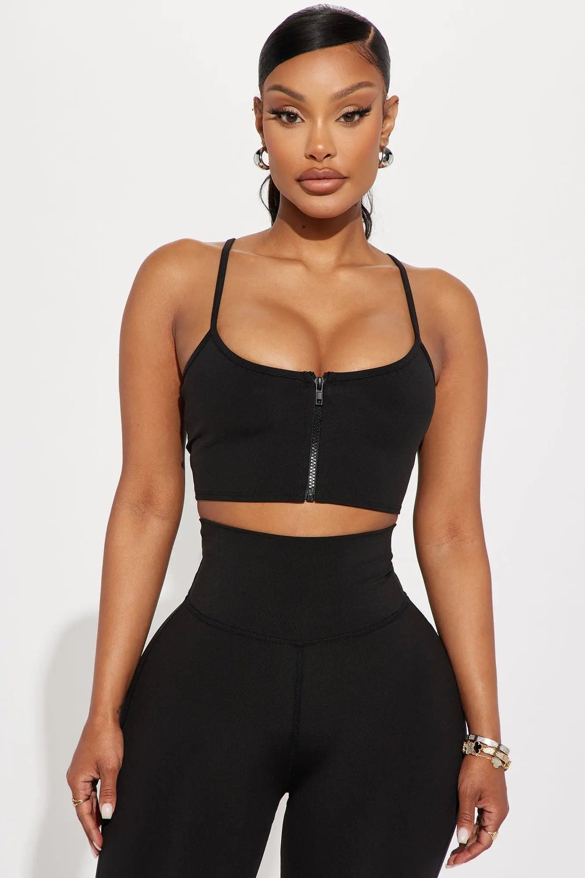 ترتدي العارضة حمالة صدر رياضية سوداء Break A Sweat Active من Fashion Nova، والمعروفة أيضًا باسم القميص النشط، وسروالًا ضيقًا.
