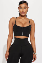 ترتدي العارضة حمالة صدر رياضية سوداء Break A Sweat Active من Fashion Nova، والمعروفة أيضًا باسم القميص النشط، وسروالًا ضيقًا.