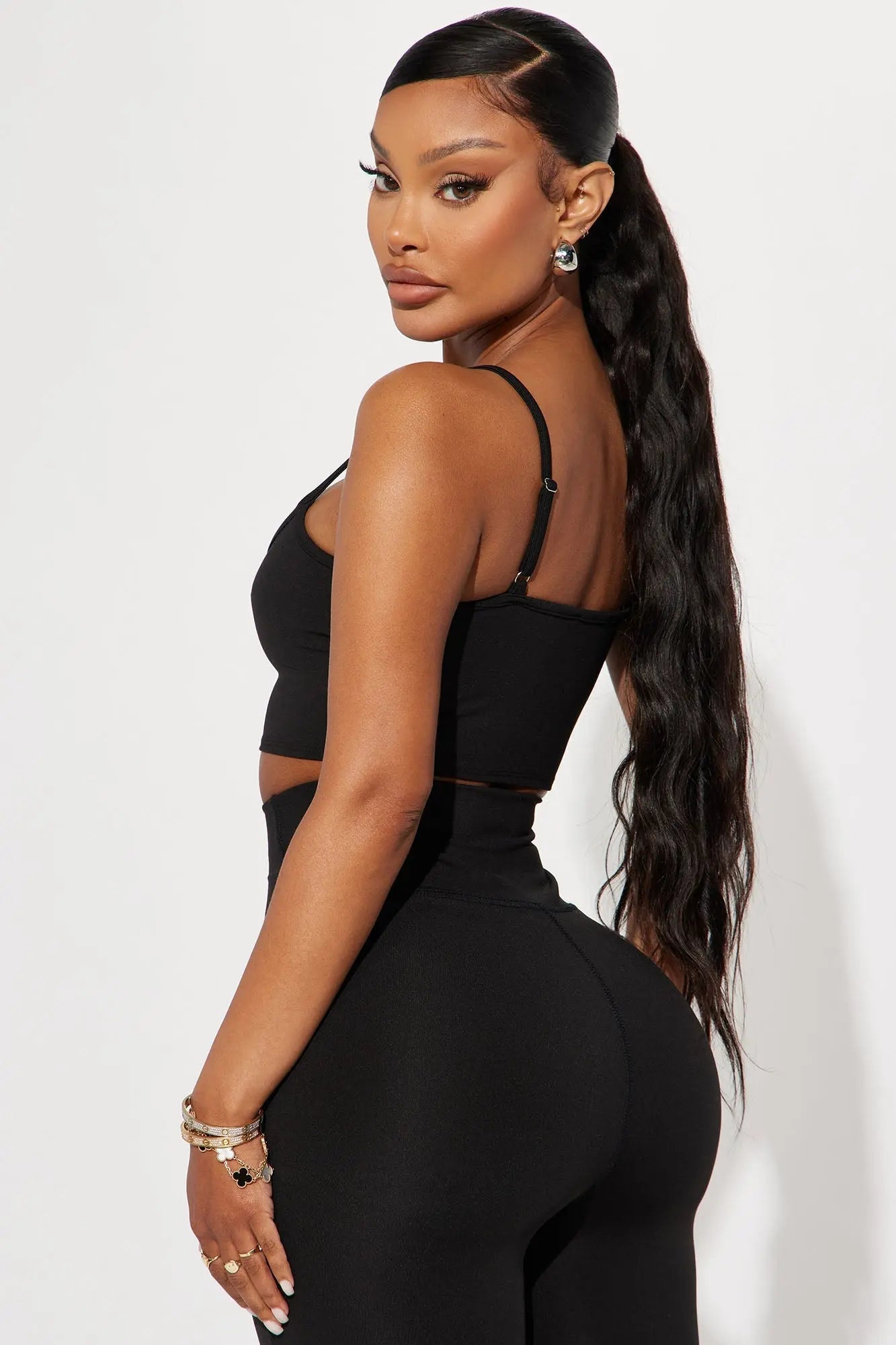 المنظر الخلفي لامرأة ترتدي بنطالًا أسودًا، ترتدي حمالة صدر رياضية من Fashion Nova Break A Sweat Active - بلوزة قصيرة سوداء.