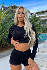 امرأة ترتدي بلوزة Nova Block Me Active Top Infinity Seamless من Fashion - باللون الأسود والسراويل القصيرة التي تلتقط صورة.