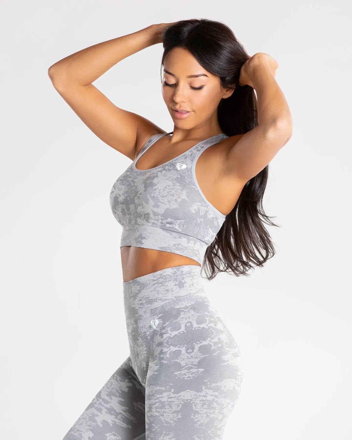 الوصف: حمالة صدر نسائية رياضية من الكامو المرن (حمالة صدر رياضية Camo Seamless | رمادي) من WOMEN'S BEST.