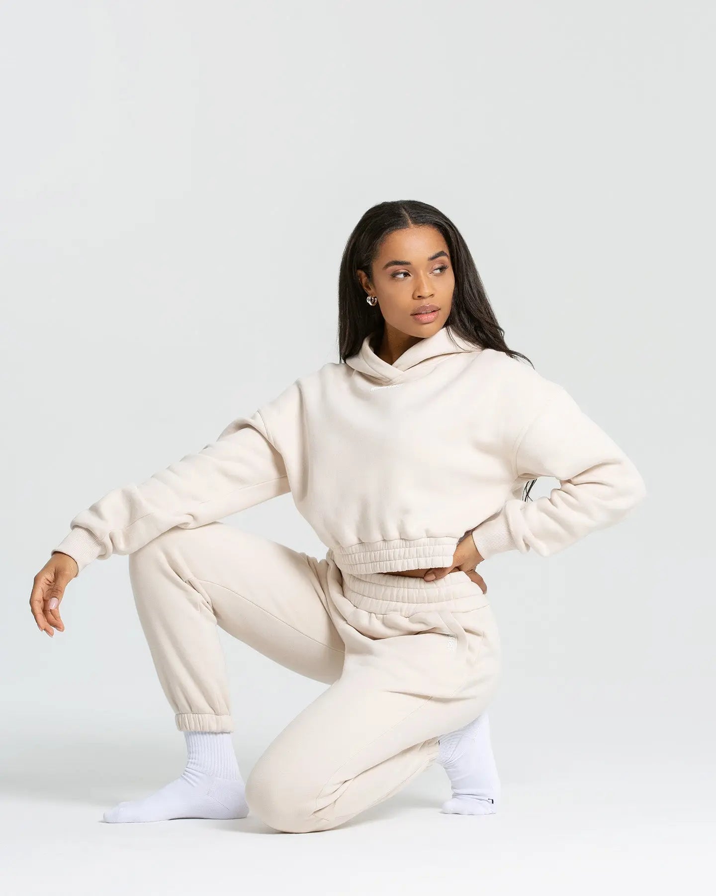 موديل يرتدي هودي "Comfort Cropped Hoodie | Sand" من WOMEN'S BEST موديل وسروال رياضي.