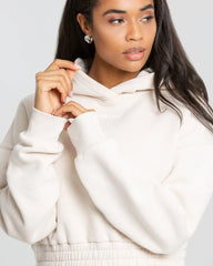النموذج يرتدي هودي "Comfort Cropped Hoodie" بقلبة وشورت رملي. من أفضل النساء.