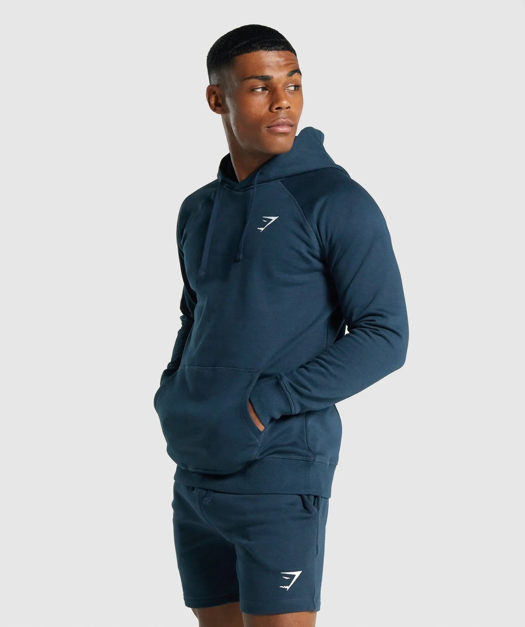 رجل يرتدي Gymshark البحرية | يونايتد وي سويت كريست هوديي.