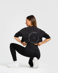 وصف: امرأة ترتدي تي شيرت أسود وقصة خاصة من WOMEN'S BEST بعنوان Comfort Oversize Cropped Long Sleeve T-shirt | أسود.