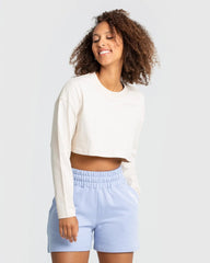 وصف: امرأة ترتدي تي شيرت "Comfort Oversize Cropped Long Sleeve T-shirt" للعلامة التجارية WOMEN'S BEST أبيض.