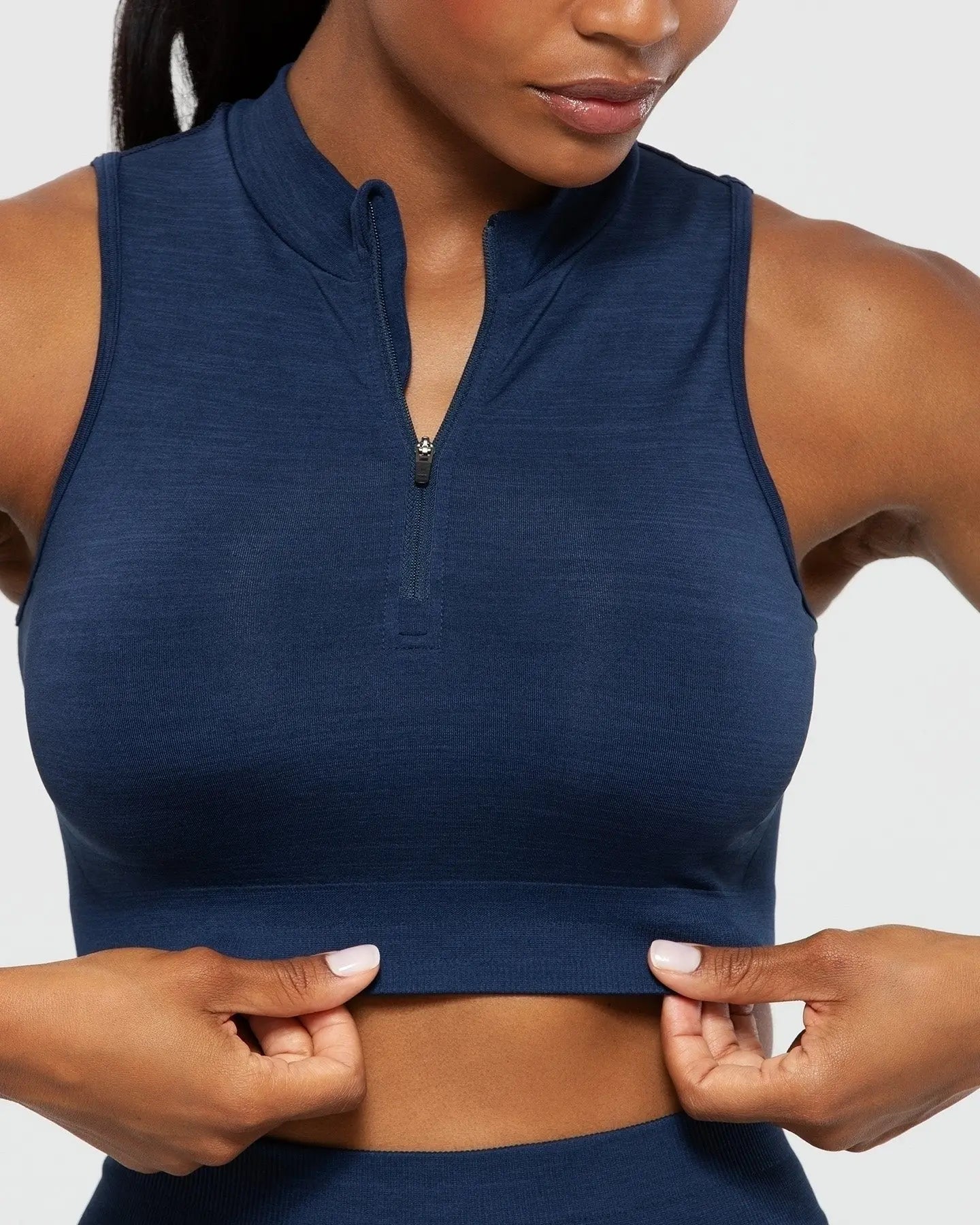 امرأة ترتدي قميص BEST Define Seamless نصف سحاب للنساء باللون الأزرق الياقوتي.