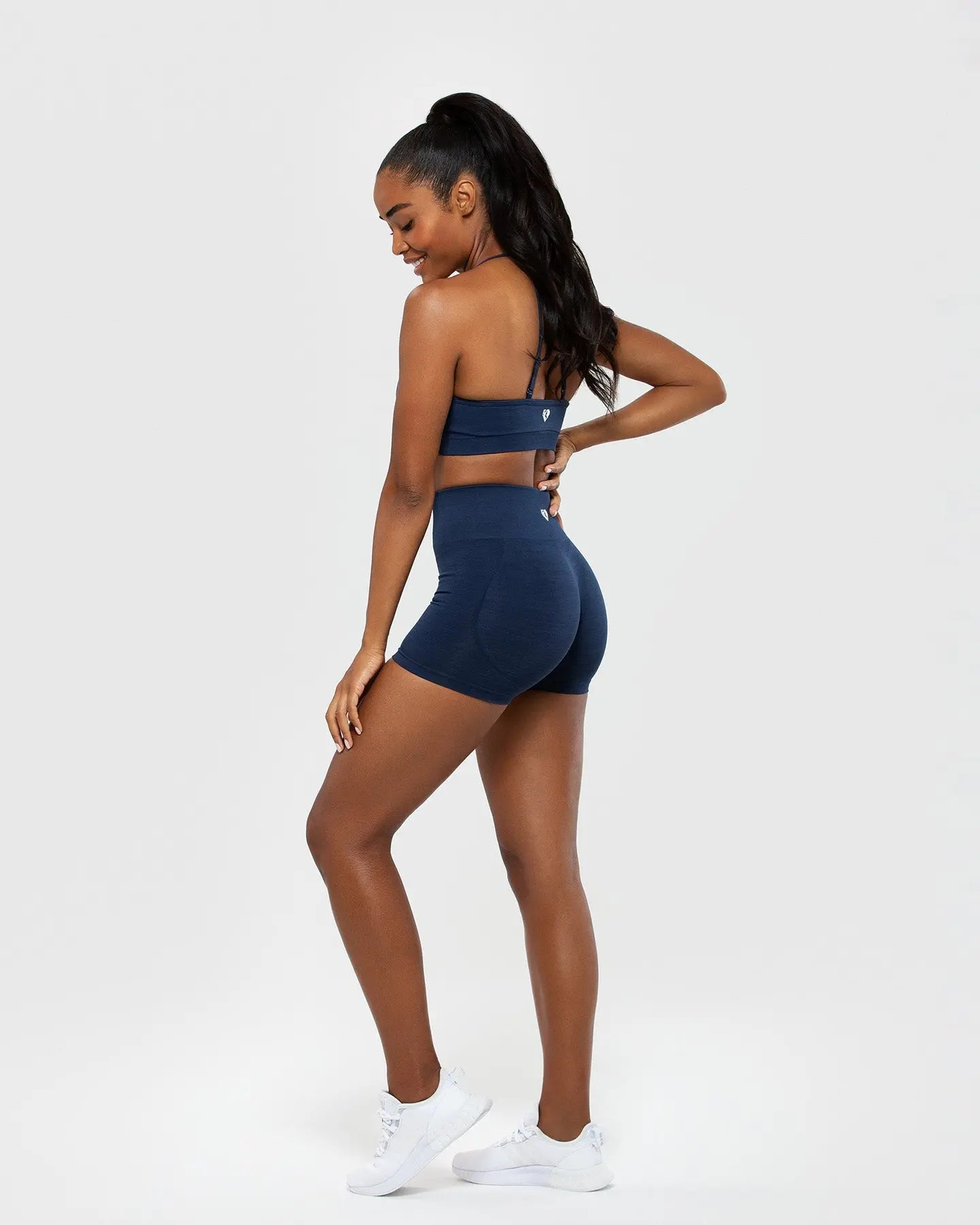 المنظر الخلفي لامرأة ترتدي شورت Best Define Scrunch Seamless للسيدات باللون الأزرق الياقوتي وحمالة صدر رياضية وشورت باللون الأزرق الياقوتي.