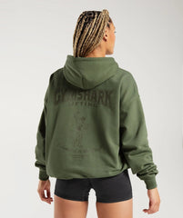وصف: امرأة ترتدي كنزة بغطاء رأس Commident To The Craft Hoodie ذات كلمات Gymshark عليها.