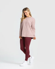 ترتدي تي شيرت نسائي "Comfort Oversize Long Sleeve T-shirt" بأكمام طويلة وبنطلون باللون الوردي. من أفضل النساء.