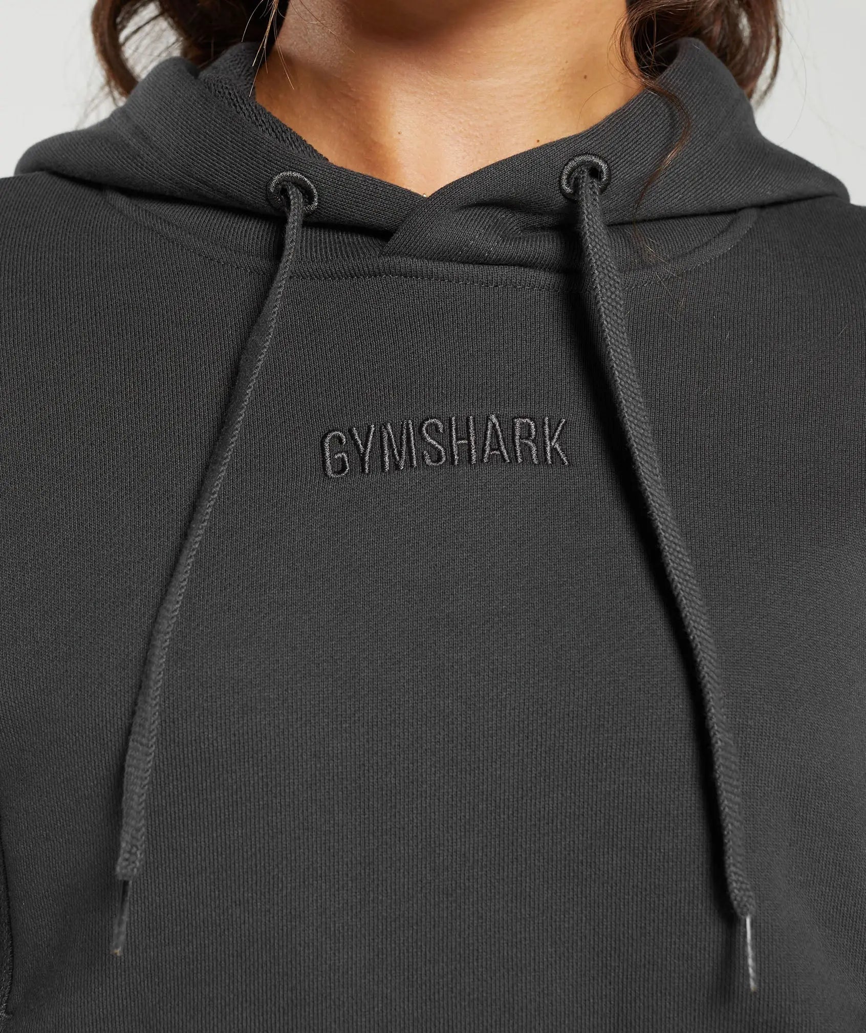 وصف: ملابس نسائية بغطاء للرأس ثقيل الوزن من نوع Loopback Sweat باللون الأسود بكلمة Gymshark | متحدون نحن نتعرق عليه.