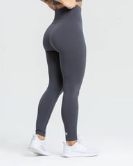 المنظر الخلفي لامرأة تعرض أفضل ما لديها من طماق نسائية بدون خياطة | حجر رمادي صلب.