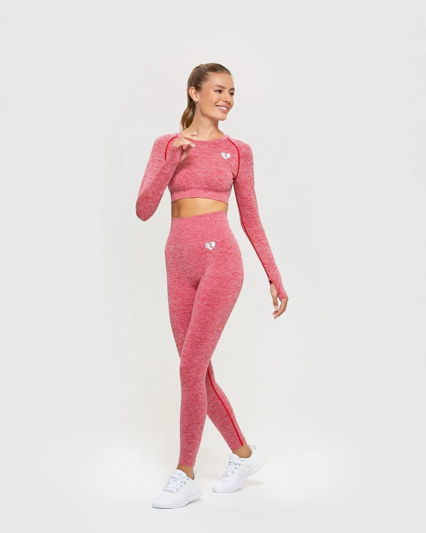 امرأة ترتدي قميصًا أحمر اللون من ماركة BEST Marl Move بدون خياطة بأكمام طويلة وسروالًا ضيقًا.