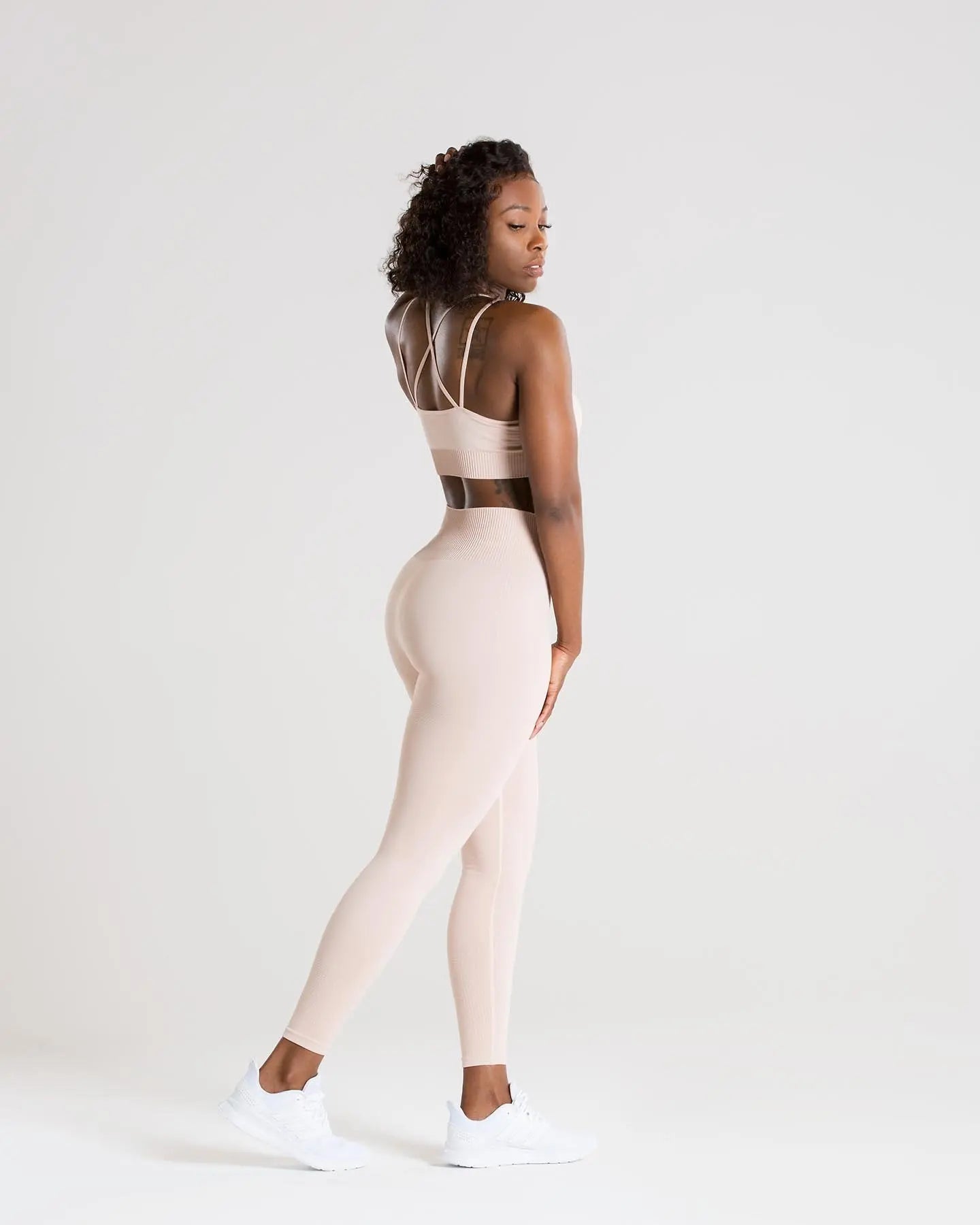 المنظر الخلفي لامرأة ترتدي حمالة صدر رياضية بدون خياطة من BEST للنساء | عارية وطماق.