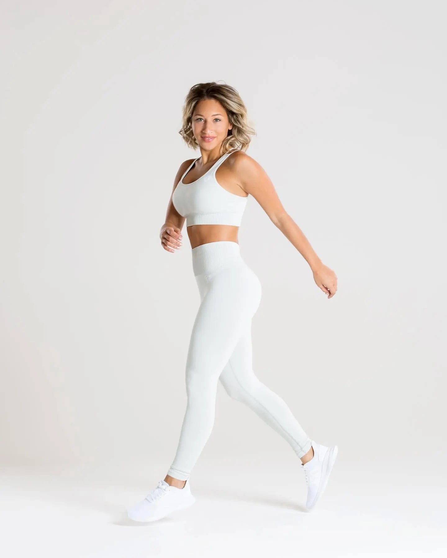 امرأة ترتدي حمالة صدر رياضية بدون خياطة من أفضل النساء | رمادي فاتح مغسول وطماق.