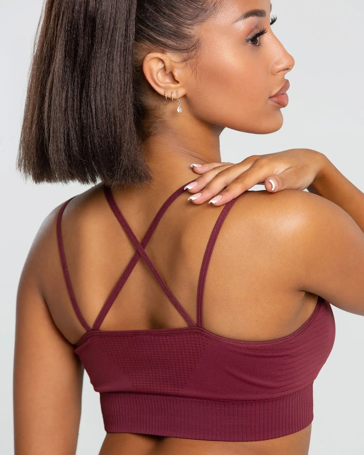 تظهر المرأة في الصورة من الخلف، وهي ترتدي حمالة صدر رياضية بدون خياطة من BEST Power للنساء | بورجوندي.