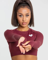 امرأة رياضية ترتدي قميصًا قصيرًا بأكمام طويلة بدون خياطة من BEST للنساء | بلوزة بورجوندي.