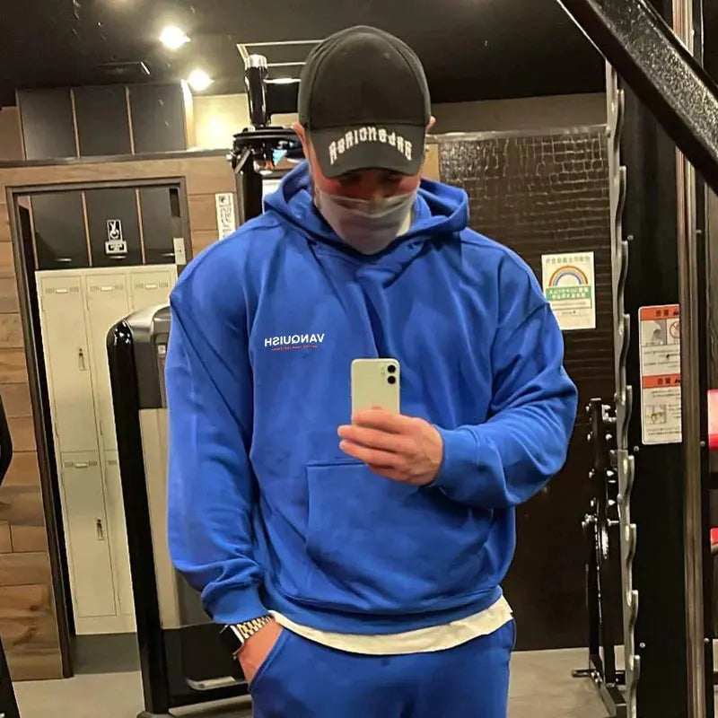 رجل يرتدي سترة باور أب يلتقط صورة سيلفي في صالة الألعاب الرياضية ويستعرض أسلوبه السعودي.