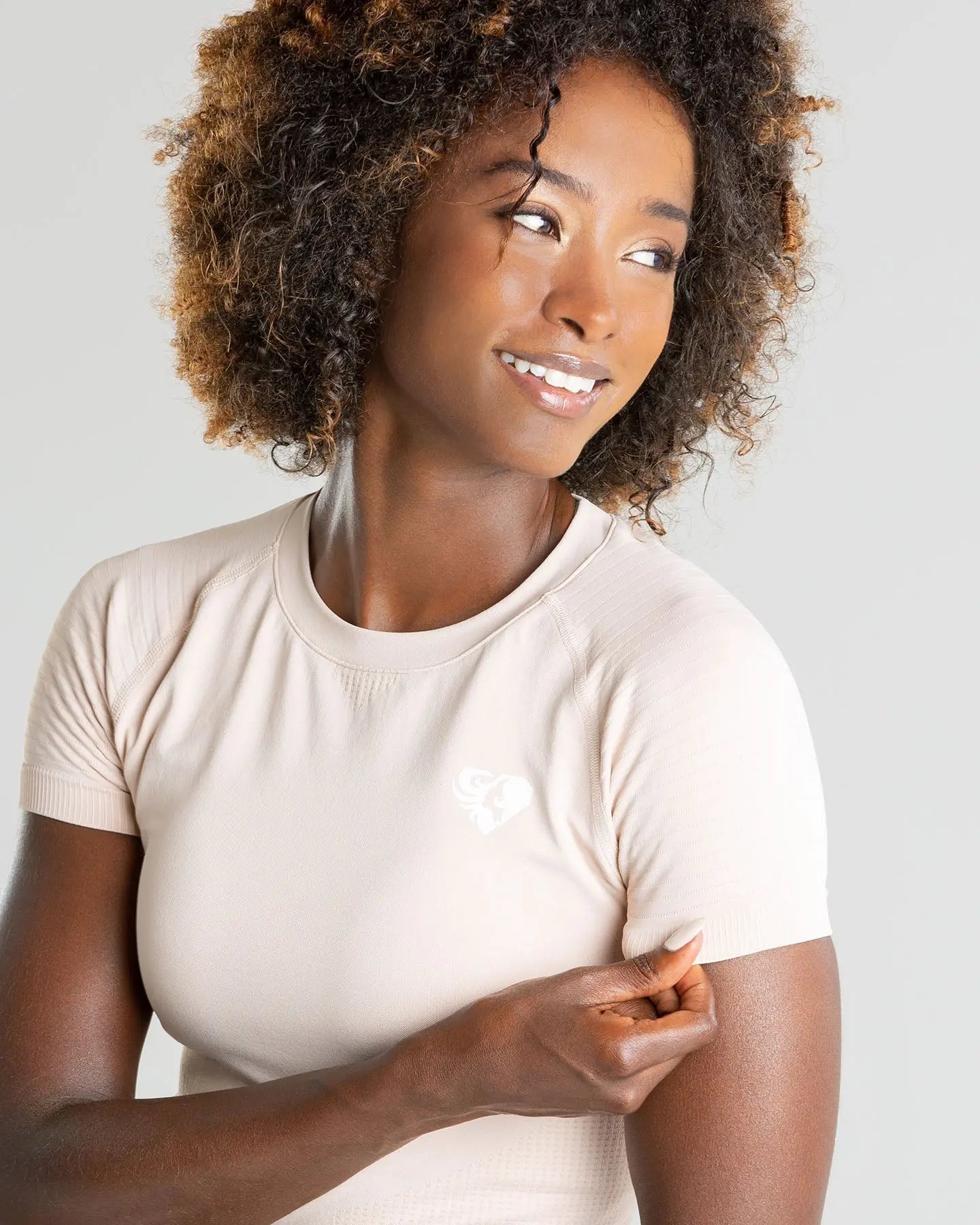 امرأة ترتدي تي شيرت BEST Power Seamless باللون البيج | عارية تشكل لالتقاط الصورة.