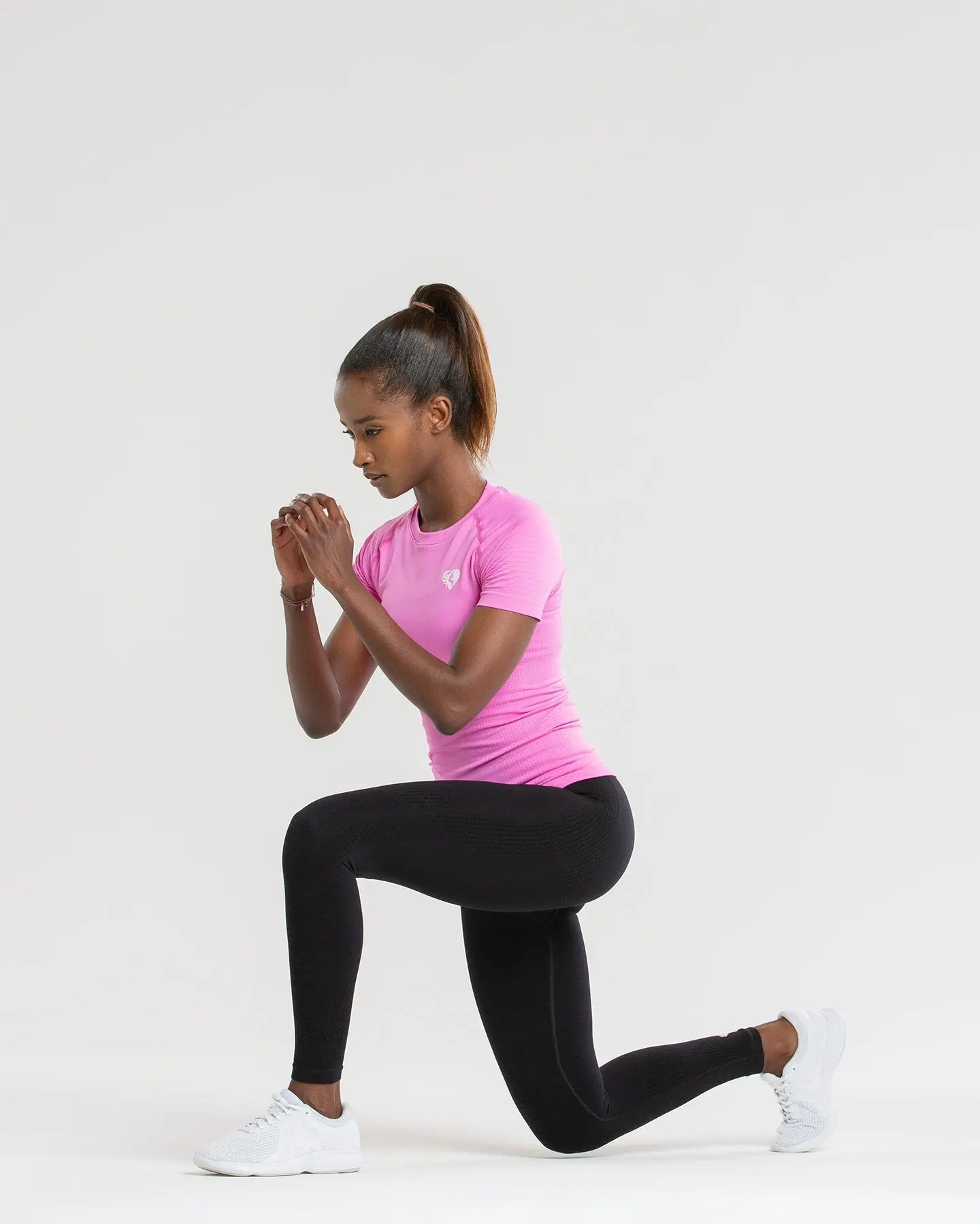 تمارين تقوم بها النساء في الزناد على خلفية بيضاء باستخدام قميص Power Seamless من WOMEN'S BEST الفوشيا (Phlox Pink).