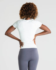 الجزء الخلفي لامرأة ترتدي طماق رمادية وتي شيرت نسائي بدون خياطة من BEST Power | رمادي فاتح مغسول بتصميم سلس.